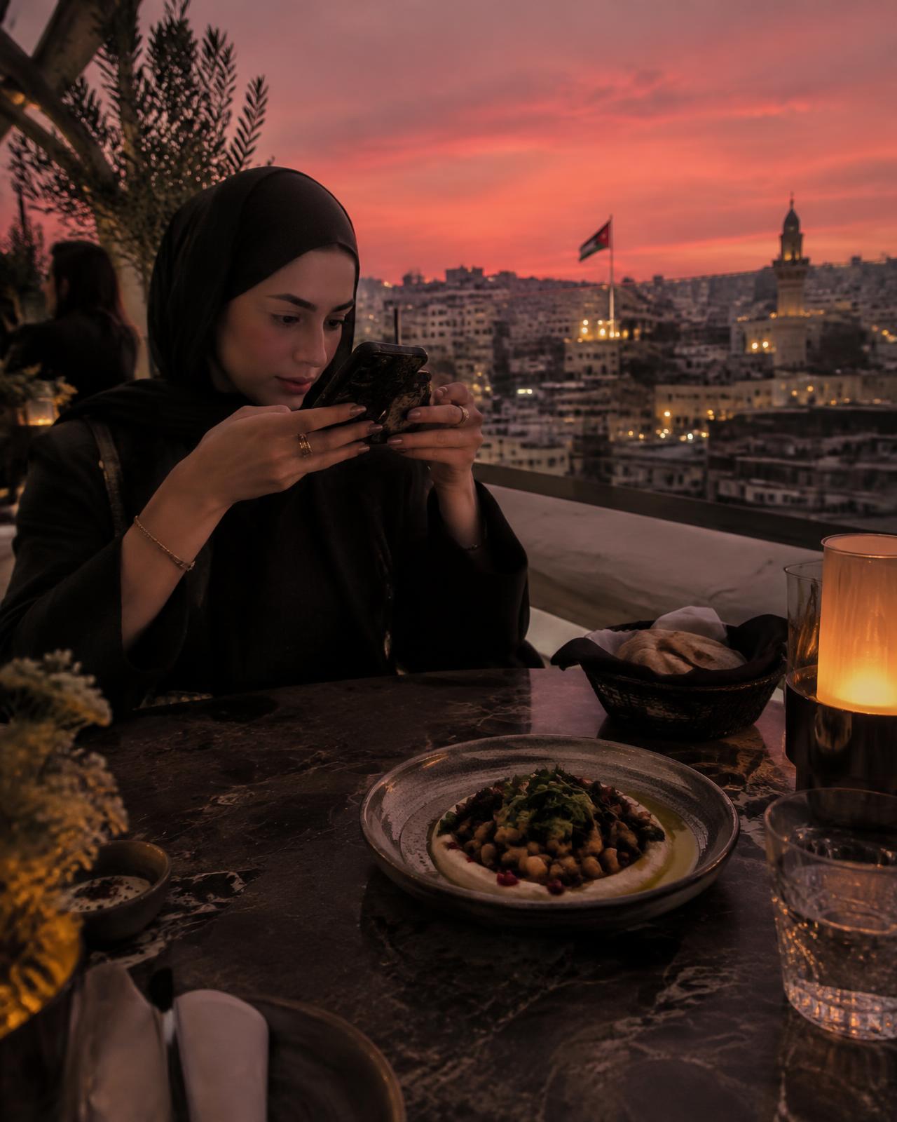 Creator filming dinner on an Amman rooftop at sunset